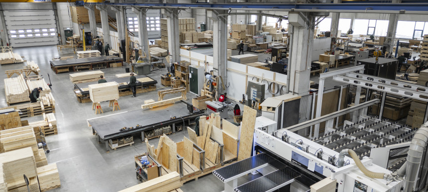 Große Werkhalle mit Holzplatten, Maschinen und Arbeitsbereichen für Holzbearbeitung