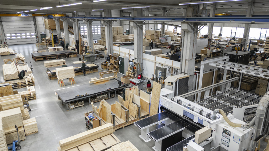 Große Werkhalle mit Holzplatten, Maschinen und Arbeitsbereichen für Holzbearbeitung