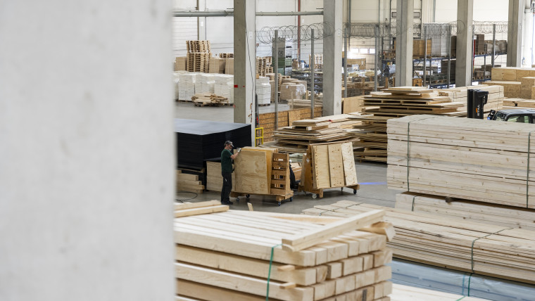 Innenansicht eines großen Lagerhauses, gefüllt mit vielen Holzpaletten.